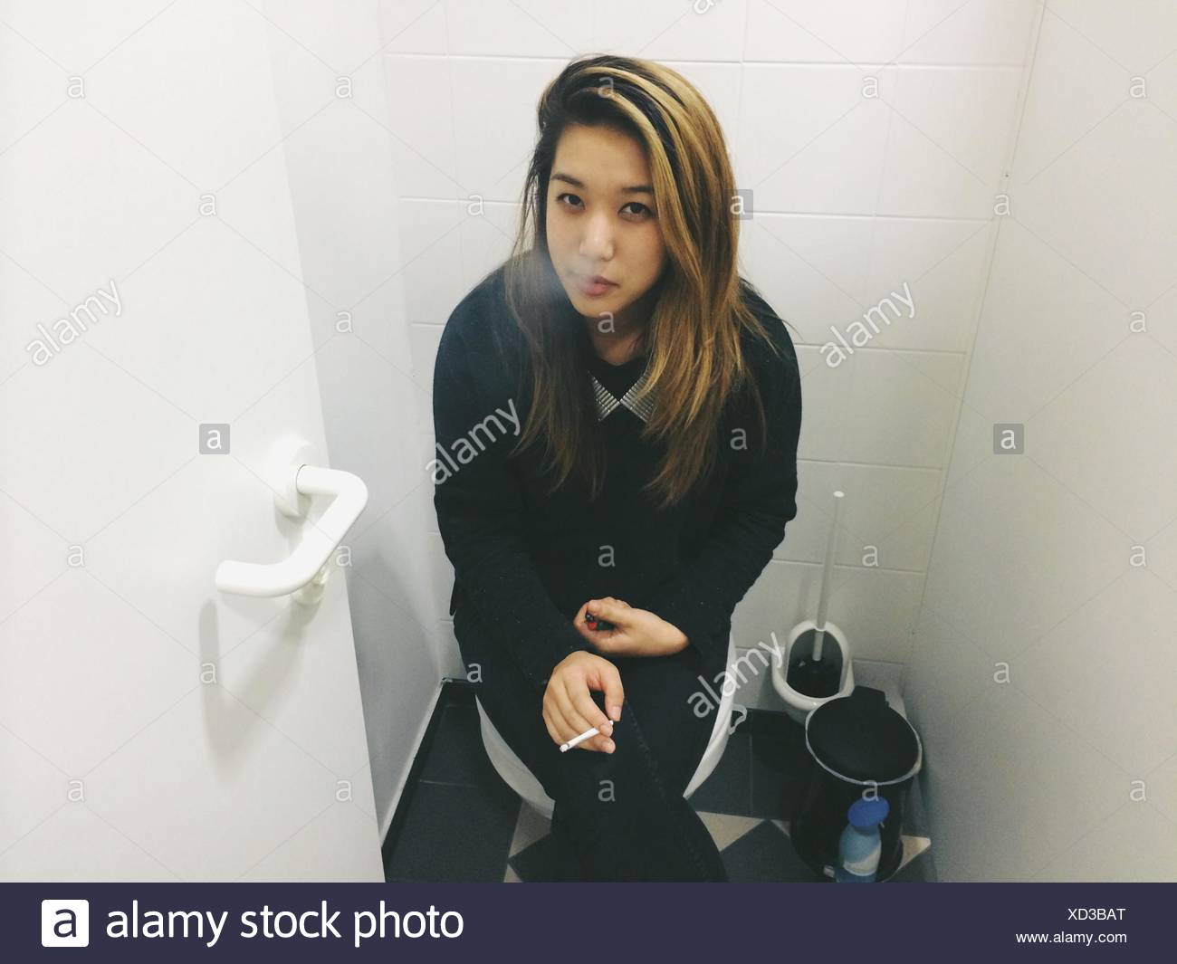 Portrait Of Woman Smoking Cigarette While Sitting On Toilet intended for measurements 1300 X 1065